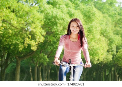 Young Woman Riding Bike And Listening Music