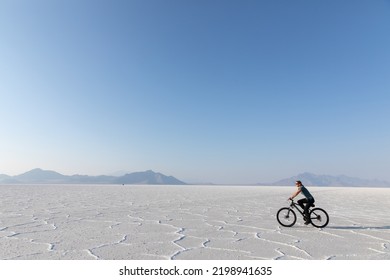 Young woman riding a bike on Bonneville Salt Flats in Utah - Powered by Shutterstock