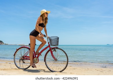 Young Woman Riding A Bike On A Tropical Beach