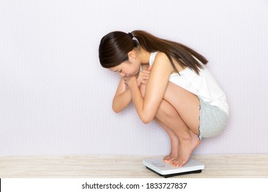 Young Woman Riding A Weight Scale.