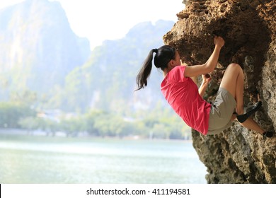 Young Woman Rock Climber Climbing At Seaside Mountain Rock