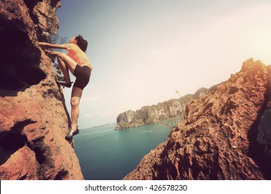 Young Woman Rock Climber Climbing At Seaside Mountain Rock