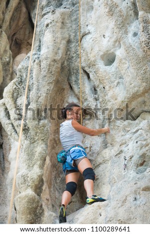 Young woman rock climbing on white mountain  in Thailand