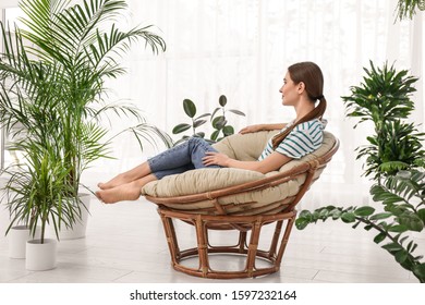 Young woman in room decorated with plants. Home design - Shutterstock ID 1597232164