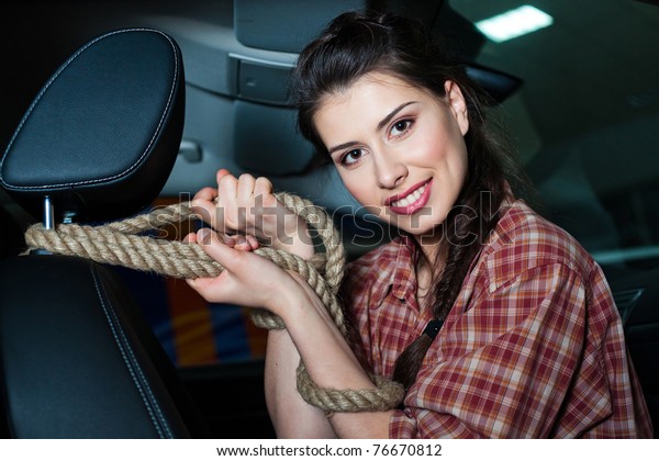 Young woman with rope inside New car with
leather interior
