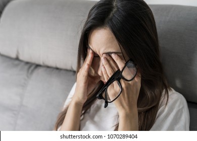 Young Woman Rubbing Her Eyes Feel Painful And Take Off Her Glasses Siiting On Sofa And Rest One's Eyes At Home, Vision Problem