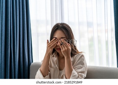 Young Woman Rubbing Her Eyes Feel Painful And Take Off Her Glasses Siiting On Sofa And Rest One's Eyes At Home, Vision Problem