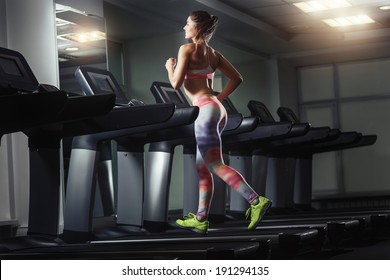 Young Woman Run On On A Machine At The Gym