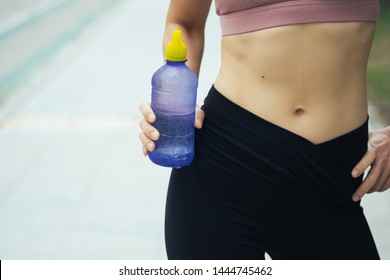 Young Woman Runner Carrying Water Bottles.