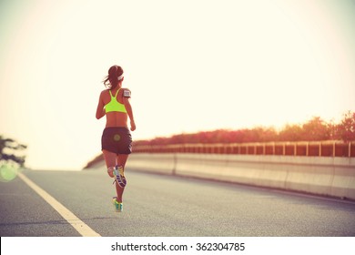 young woman runner running on city bridge road - Shutterstock ID 362304785