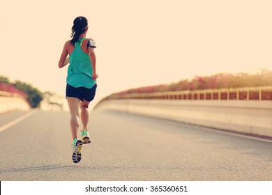 young woman runner running on city bridge road - Shutterstock ID 365360651