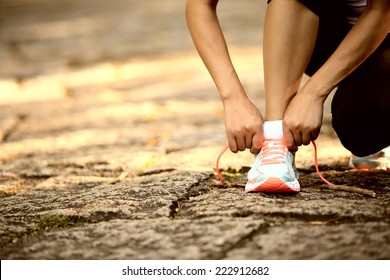 young woman runner tying shoelaces outdoor