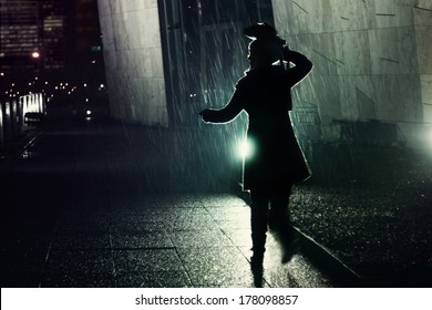 Young Woman Running Away From The Rain At Night, Protecting Her Head With Her Bag