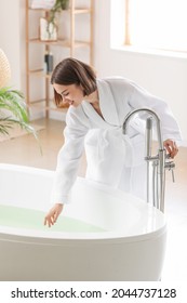 Young Woman Running Bathtub With Warm Water At Home