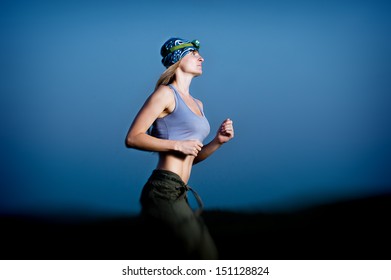 Young Woman Running In The Dark With Headlamp Outdoor