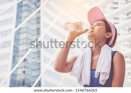 Young woman running and drinking water