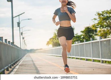 Young woman running in the nature. Healthy lifestyle and sport concepts.  Runner training in a urban area.The woman with runner on the street be running for exercise. 