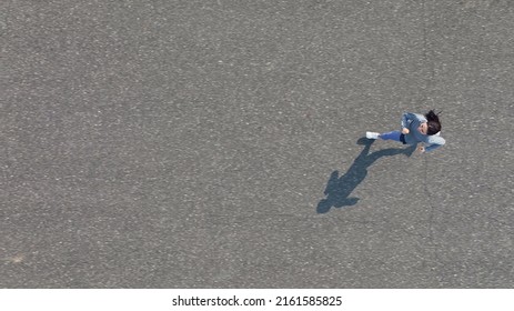 Young woman running on the road. Directly above view. - Shutterstock ID 2161585825