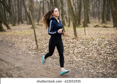 Young woman running outdoors in a city park on early spring day - Powered by Shutterstock