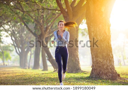 young woman running in the park at  morning