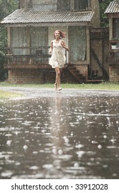 Young Woman Running In The Rain Without Umbrella