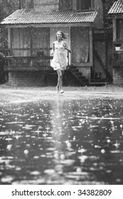 Young Woman Running In The Rain Without Umbrella