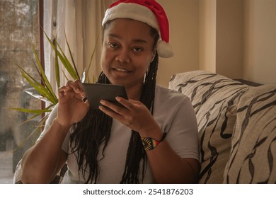 young woman with santa claus hat using digital tablet at christmas - Powered by Shutterstock