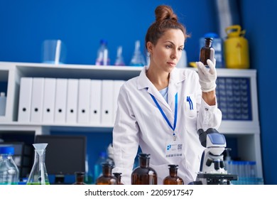 Young Woman Scientist Holding Bottle Working At Laboratory