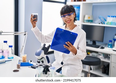 Young Woman Scientist Holding Clipboard And Sample At Laboratory