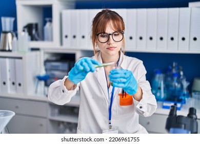 Young Woman Scientist Measuring Liquid At Laboratory