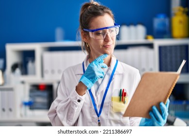 Young Woman Scientist Reading Book At Laboratory