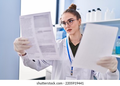 Young Woman Scientist Reading Document At Laboratory