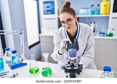 Young Woman Scientist Using Microscope At Laboratory