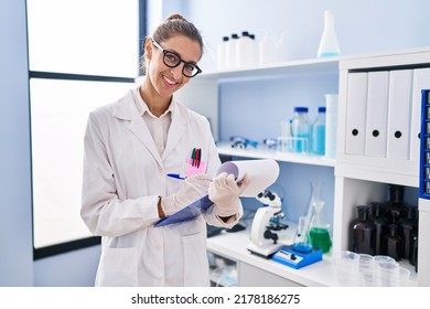 Young Woman Scientist Writing On Clipboard At Laboratory