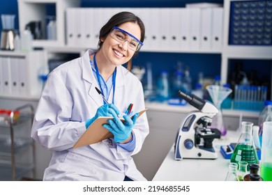 Young Woman Scientist Writing On Notebook At Laboratory