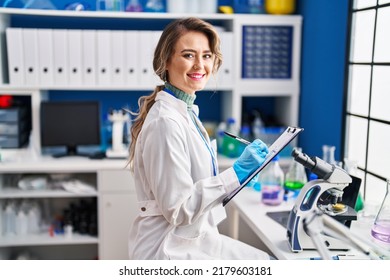 Young Woman Scientist Writing Report At Laboratory