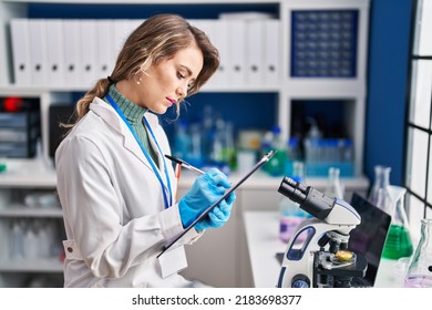 Young Woman Scientist Writing Report At Laboratory