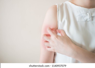 Young Woman Scratching Arm From Having Itching On White Background Copy Space. Cause Of Itchy Skin Include Insect Bites, Dermatitis, Food/drugs Allergies Or Dry Skin. Health Care Concept. Close Up.