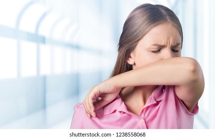 Young woman scratching her nose with elbow on background - Powered by Shutterstock