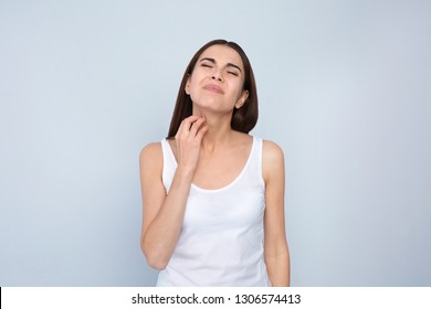 Young Woman Scratching Neck On Light Background. Annoying Itch