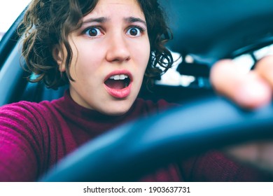 Young Woman Screams In Fear At Wheel Of Car. Curly Girl Driver Is Panicked And Very Scared Of Accident.