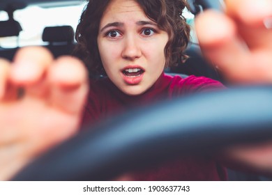 Young Woman Screams In Fear At Wheel Of Car. Curly Girl Driver Is Panicked And Very Scared Of Accident.