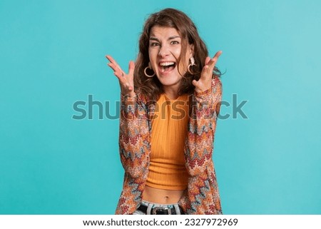 Young woman screams yell shout from stress tension problems feels horror hopelessness fear panic surprise shock expresses gestures rage. Pretty girl isolated on blue studio background indoors