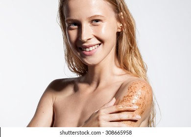 Young woman with scrub cleanses the skin