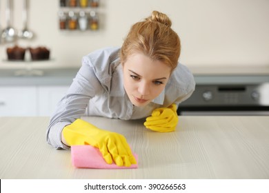 Young Woman Scrubbing The Bar In Kitchen