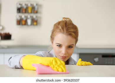 Young Woman Scrubbing The Bar In Kitchen