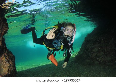 Young Woman Scuba Diving Into Underwater Cave