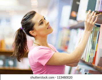 Young Woman Searching For A Book In Bookstore