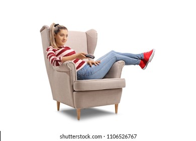 Young Woman Seated In An Armchair Watching TV Isolated On White Background