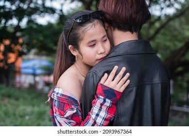 A young woman seeking comfort hugs her boyfriend, in a time of distress.